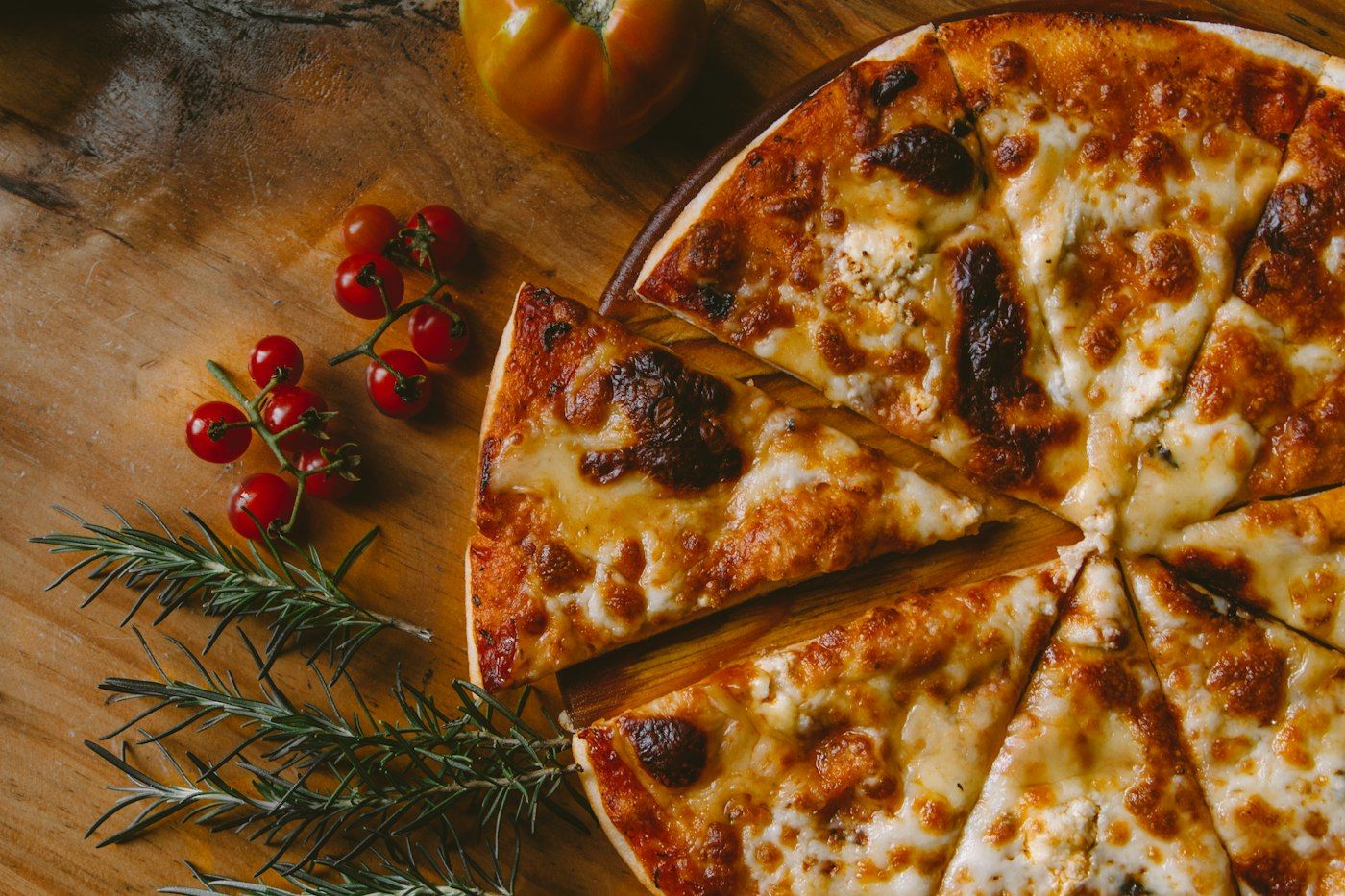 Pizza tagliata a spicchi con pomodorini e rosmarino